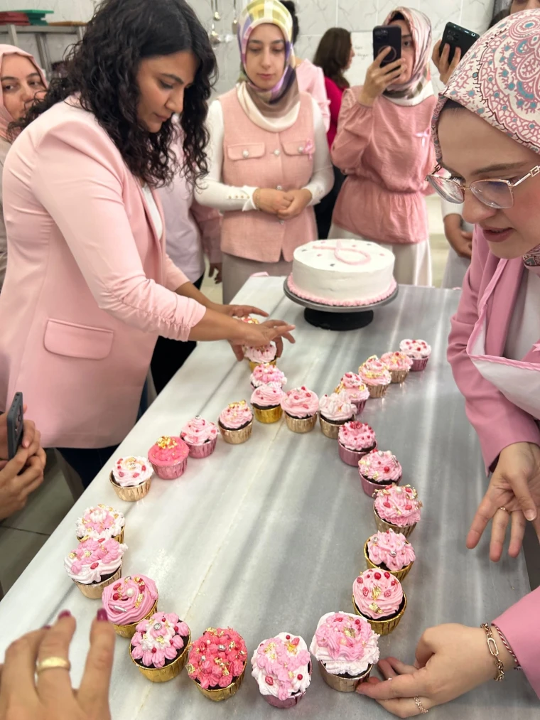 Gürün'de farkındalık etkinliğinde pembe keklerle kurdele düzeni hazırlayan katılımcılar